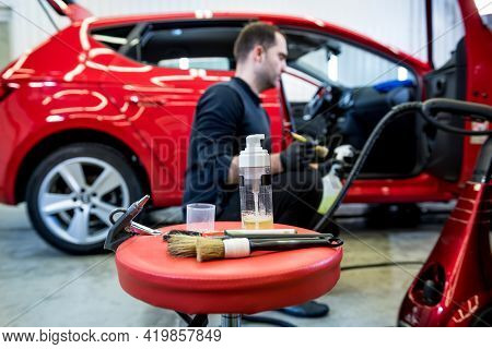 Car Service Worker Cleans Interiror With Special Brush