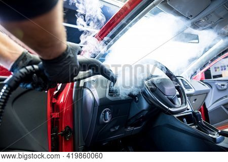 Car Service Worker Cleans Interiror With Steam Cleaner