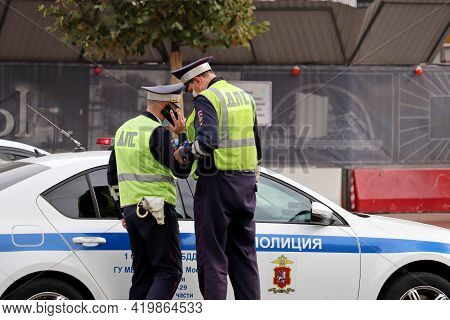 Moscow, Russia - May 2021: Two Traffic Police Officers In Masks Standing Near The Car On The Road. P
