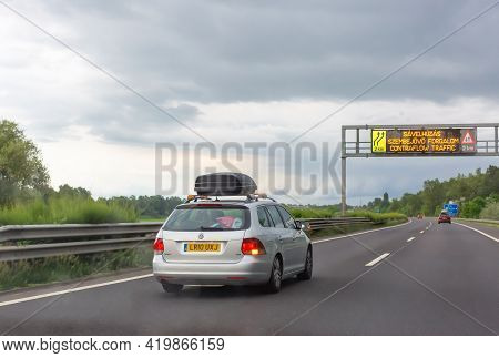 Godollo, Hungary. June 16, 2020: Silver Car With Black Roof Luggage Box Driving On The Road