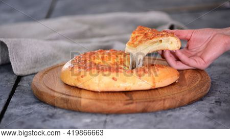 Freshly Baked Megrel Khachapuri With Cheese On A Wooden Table.