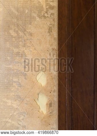 Old Badly Damaged Wallpaper By A Wooden Doorpost