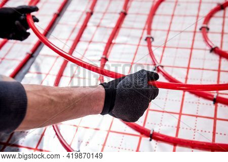 Pipefitter Install System Of Underfloor Heating System At Home