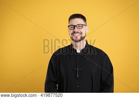 Priest Wearing Cassock With Clerical Collar On Yellow Background