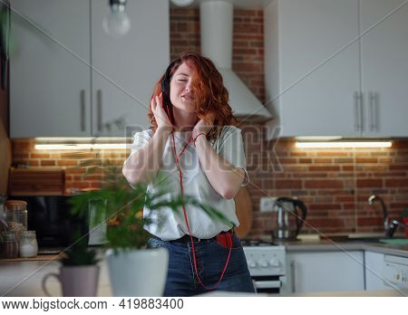 Overjoyed Millennial Woman Have Fun In Home Kitchen.