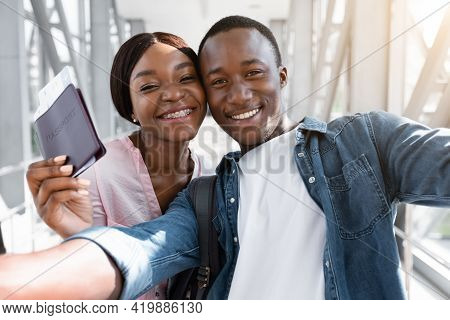 Portrait Of Happy Young Black Couple Taking Selfie In Airport Terminal