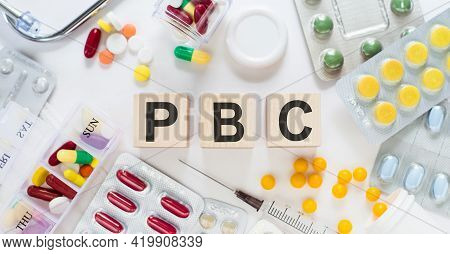 Pbc - Primary Biliary Cholangitis, Word On Wooden Blocks On A Desk. Medical Concept With Pills, Vita