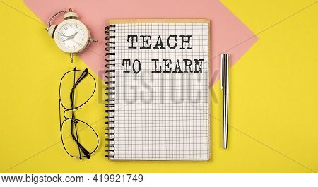 Teach To Learn Text On The Notebook With Pen On The Yellow Background With Pen, Glasses And Alarm Cl