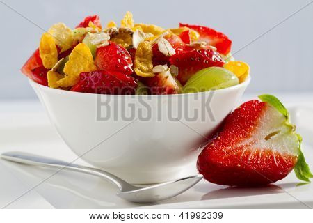 Dieta, muesli con insalata di fragole e frutta nella ciotola bianca - sana colazione, peso perdita conc