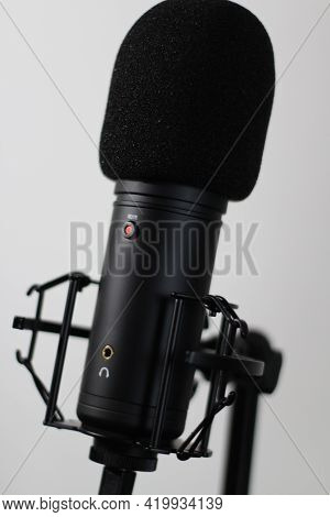 Generic Cardioid Microphone With Pop Filter And Shock Mount And Live Red Led In A Clean Setting.