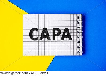 Text Capa On Page Notebook With Cage Lies On A Blue And Yellow Background, Top View. Corrective And 