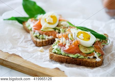 Open Sandwich Traditional Danish Smorrebrod Salmon, Cucumber, Boiled Egg, Soft Cheese. Homemade Sand