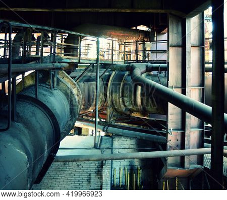 Old Abandoned Factory Interior With Many Rusty Piping. Big Rusty Piping In The Factory.