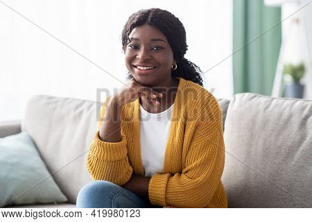 Attractive Black Lady Posing On Couch At Home