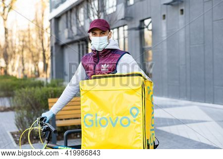 Kiev, Ukraine - April 28, 2021: Glovo Bike Courier On The Street. Delivery Boy Of Glovo Delivery Ser