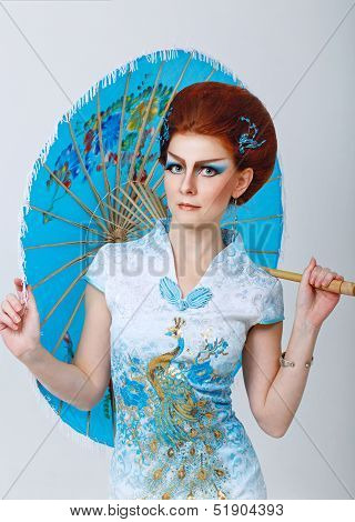 Geisha In A Smart Dress With Umbrella