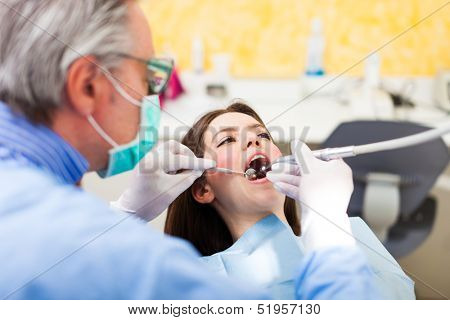 Dentist doing a dental treatment on a young woman