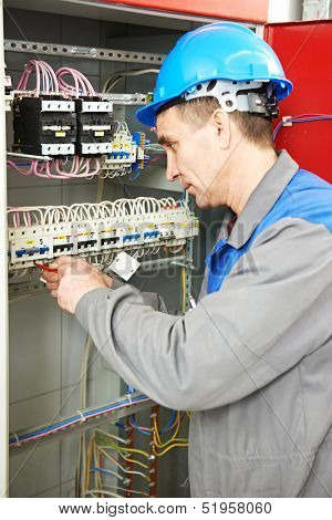 electrician at work checking wire with drawing inspecting high voltage power electric line distribution fuseboard
