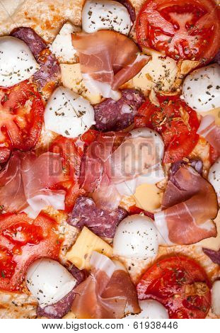 Raw pizza dough with mozzarella and proscuitto on top