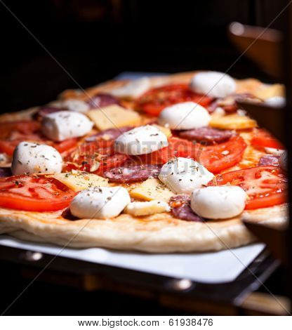 Raw pizza dough with mozzarella and proscuitto on top