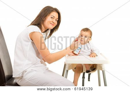 Happy Mom Feeding Toddler Boy With Yogurt