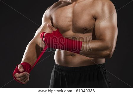 Portrait of a body combat athlet aplying tape on the hands