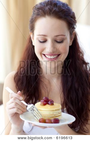 Lächelnde Frau eine süße Dessert essen