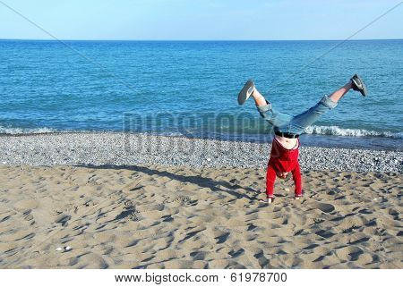 Young girl doing cartwheel on a beach