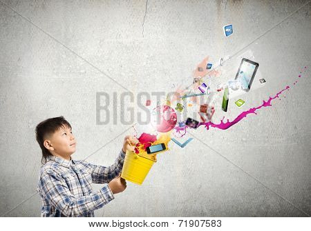 Young boy splashing colorful paint from bucket