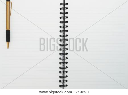 Anel em branco vazia, o bloco de notas espiral, uma caneta de ouro à esquerda