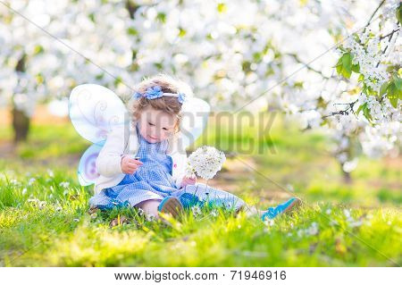 Curly Toddler Girl In Fairy Costume Playing In Fruit Garden