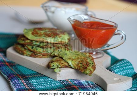 zucchini fritter with sour cream and hot pepper sauce