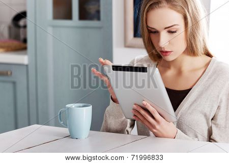 Young beautiful woman using a tablet computer at home