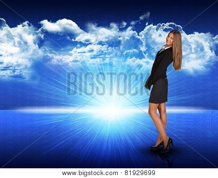 Businesswoman standing against blue landscape with rising sun