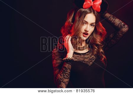 Portrait of a beautiful model with a red bow on a dark background.