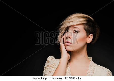 Blonde girl with a short stylish haircut on a dark background
