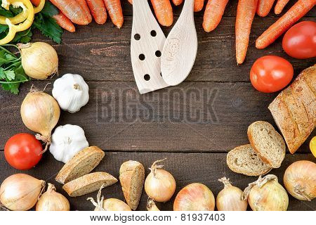 Wooden kitchenware with vegetables mix and bread on the table