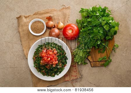Plate of traditional Arabic salad tabbouleh on a wooden plate