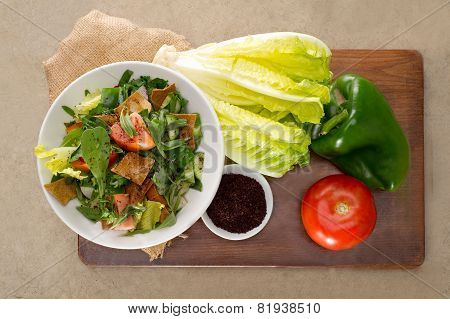 Plate of traditional Arabic salad fattouch on a wooden plate