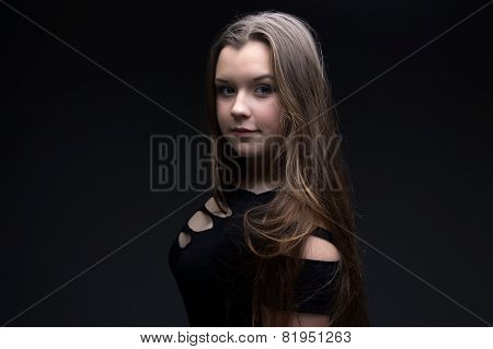 Photo of teenage girl in black dress, half-turned
