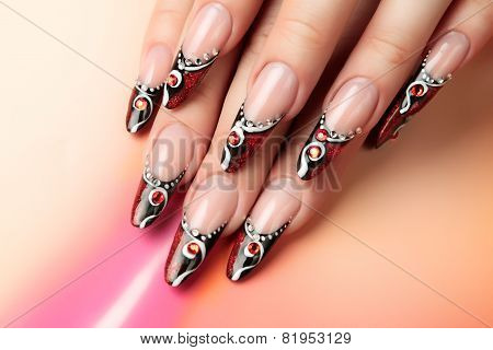 Red and black art design on nails.