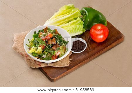Plate of traditional Arabic salad fattouch on a wooden plate