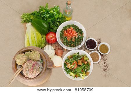 Plates of traditional Arabic salad fattouch and tabbouleh on a rustic background
