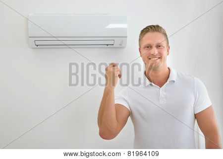 Man With Air Conditioner Remote Control