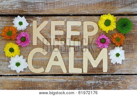 Keep calm written with wooden letters and Santini flowers