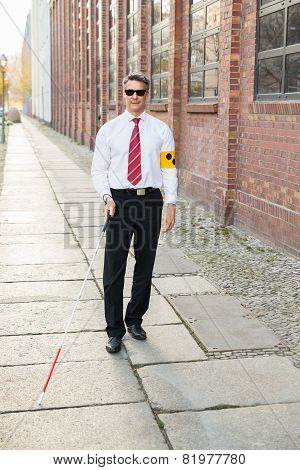 Blind Man Walking On Sidewalk Holding Stick