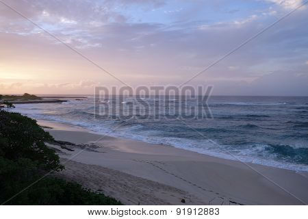 Waves Break And Crash Towards The Hanakailio Beach With Dramatic Blue-pink Cloudy Skyline At Dusk