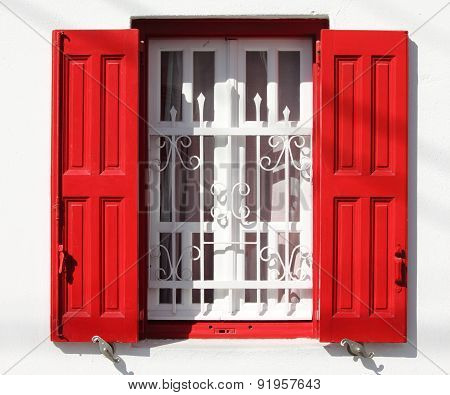Window with grille and red shutters