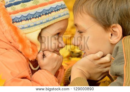 Boy and girl on a walk during the fall of the leaves in the park