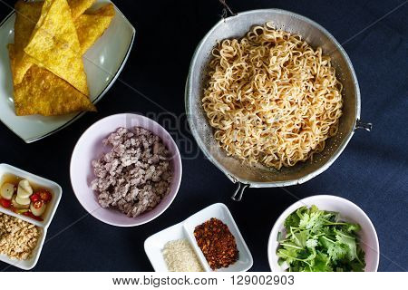 Ingredient spicy instant noodle with minced pork on wood background Top view